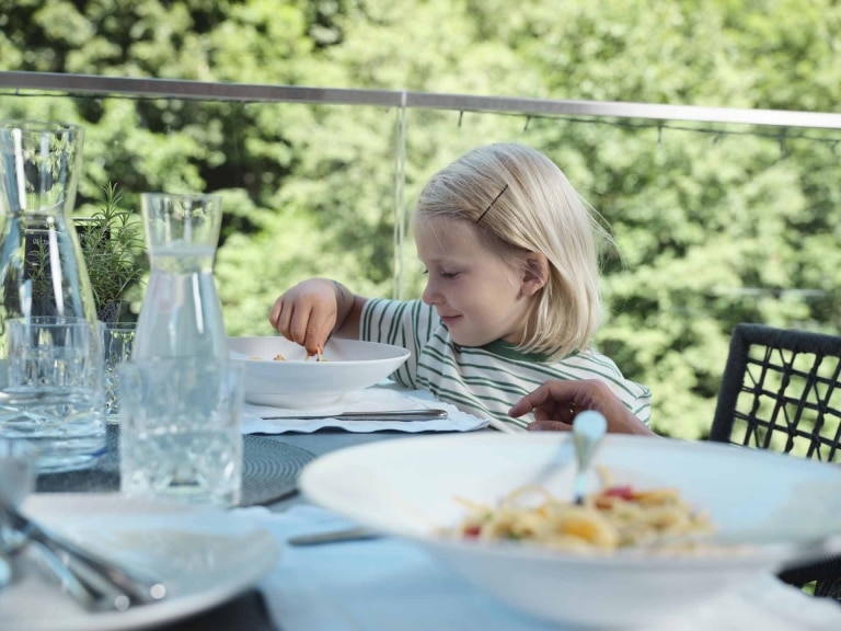 Kind isst die Pasta mit den Fingern